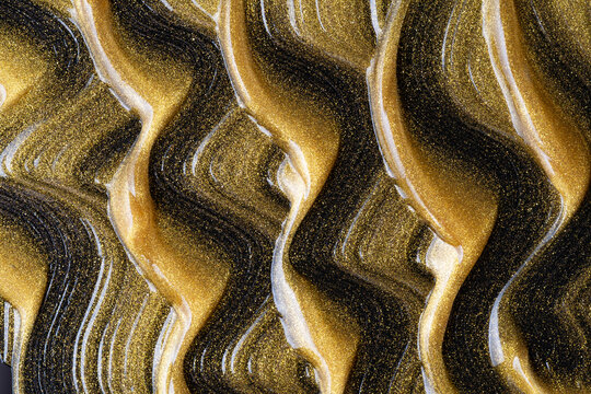 Luxurious gold oil texture with black cosmetic swirls