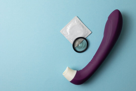 Condoms and contraceptive protection concept on color background with heart symbol