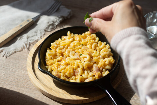 Homemade American mac and cheese with fresh herb garnish