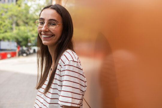 Smiling woman with glasses in urban setting