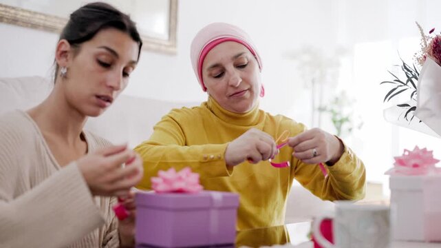 Mother with cancer and daughter preparing gifts together at home
