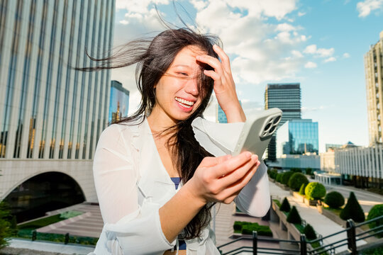 Gen z Chinese woman using smartphone in modern city