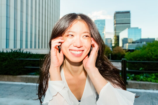 Gen Z Chinese woman smiling outdoors in modern city
