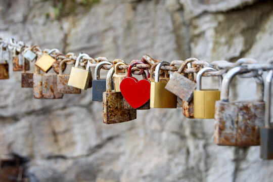 Heart-shaped padlock on a line of locks on a chain