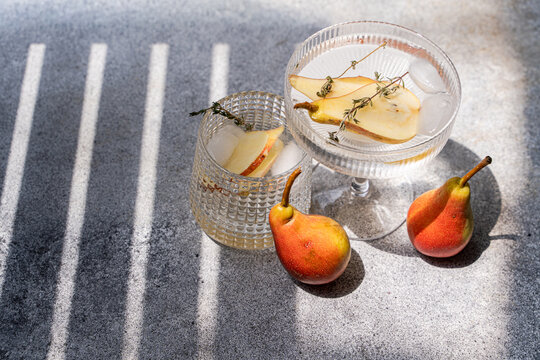 Pear and elderflower spritz cocktail with thyme and ice