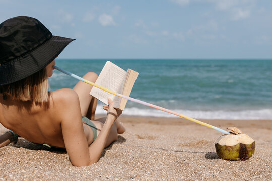Woman reading on Thailand beach embracing slow living