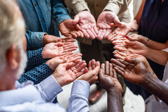 Diverse group of men and women showing open hands in a circle