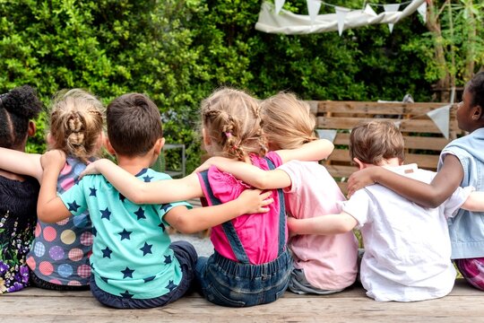 Children embracing in friendship outdoors.