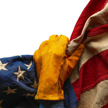 Worn work glove pulling back the American flag. Symbolic of blue collar workers, USA manufacturing, pride in products Made in United States of America, or to celebrate Father's day or US Labor Day.