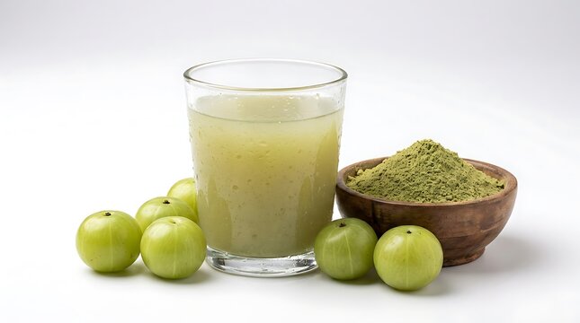 Fresh amla juice in a glass with a bowl of indian gooseberry powder and raw green amla fruits. Amla powder drink