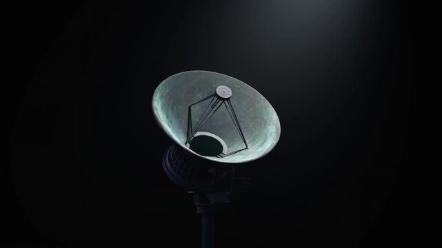 Slow motion rotation of parabolic satellite dish tilting under spotlight in dark studio environment with subtle camera pan and tracking movement