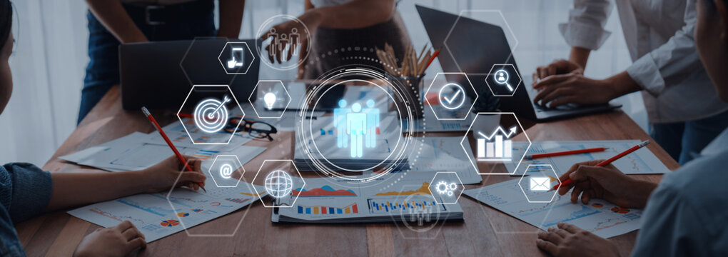 A dynamic workspace scene showcasing business professionals engaged in collaboration, analyzing charts and data with digital icons illustrating teamwork and productivity. Trope