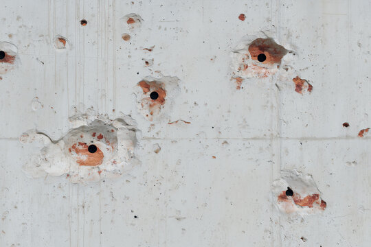 Bullet Holes and Shrapnel Damage on Concrete Wall Texture Background