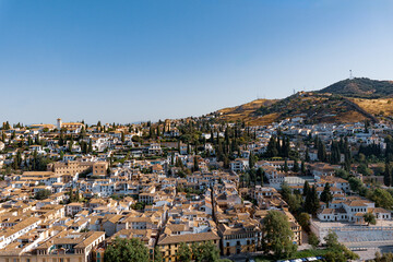 Obraz premium View of the historic neighborhood in Granada, Spain, characterized by its cascading whitewashed houses with terracotta tile roofs