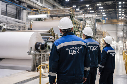 Workers Inspecting Paper Production Line at Pulp and Paper Mill