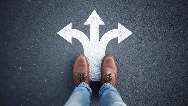 Top-down view of person standing at a crossroads with a three-way arrow sign