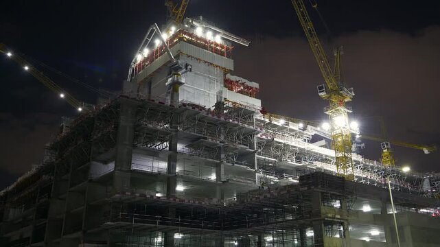 night time illuminated abu dhabi modern construction top working cranes up view panorama 4k united arab emirates