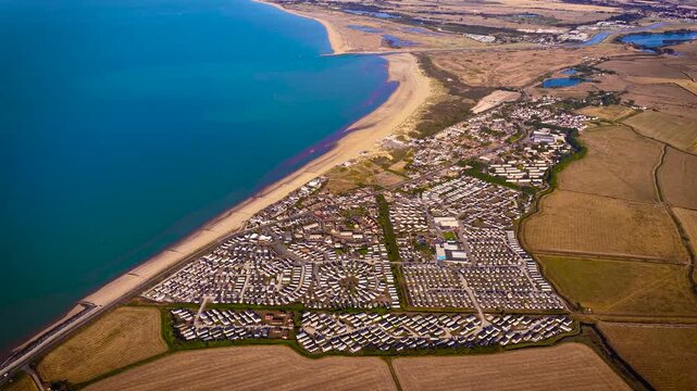 Aerial view of Camber Sands and coastal caravan parks beside farmland in East Sussex; ideal for travel, tourism, property, holiday and lifestyle advertising