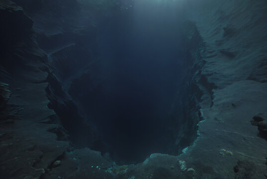 Generated fictional underwater scene with seabed and a large abyss pit.