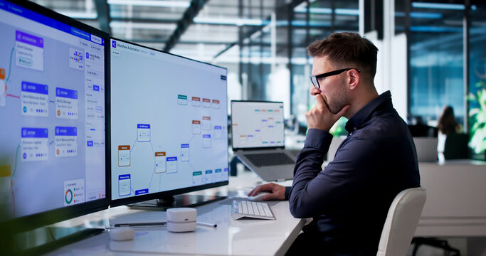 Young Man Improving Business Workflow On Computer