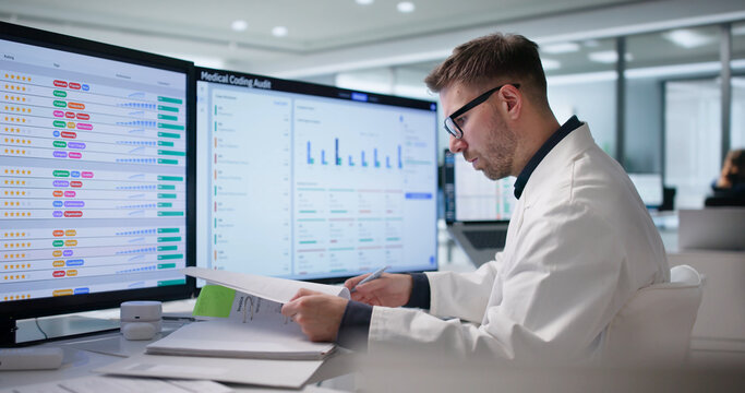 Medical Billing Specialist Reviews Coding Invoices On Computer