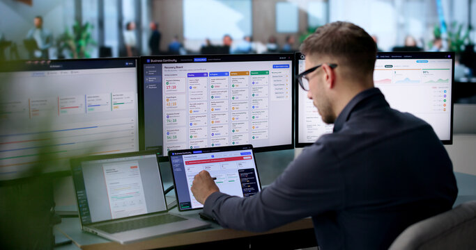 Man Uses Laptop To Monitor Live Business Dashboard