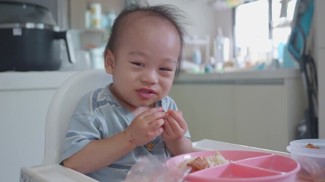 A joyful toddler sits in a high chair, happily nibbling on a snack in a bright kitchen. The scene captures the essence of childhood delight and the simple pleasures of eating.