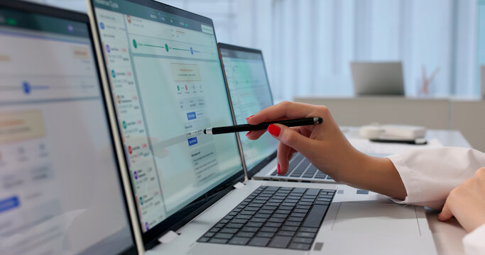 Woman Reviews Patient Billing Codes On Laptop