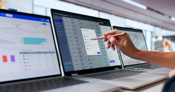 Woman Using Laptop To Check IT Asset Compliance