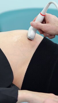 Professional doctor conducting a medical ultrasound examination on a female patient's knee, applying gel and moving the transducer across the skin to diagnose the joint for potential injuries