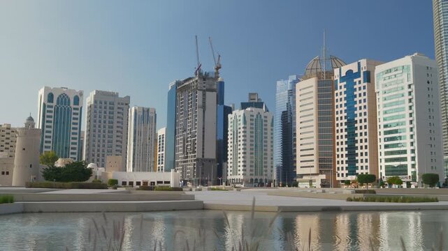 sunny day abu dhabi center cityscape new park square pond panorama 4k united arab emirates