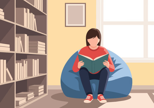 Young Student Reading Book in Library Sitting on Bean Bag Chair