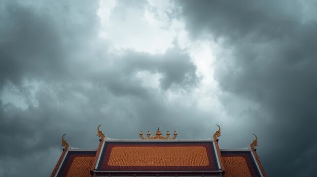 Dramatic temple rooftop with ornate golden finials against stormy monsoon sky with set against moody