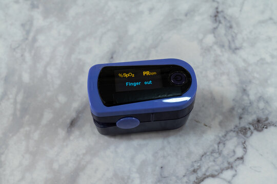 Pulse oximeter digital reading Finger out on marble table top view