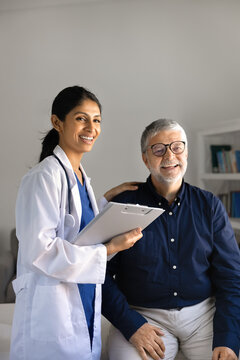 Smiling female doctor or nurse in uniform posing for portrait of positive senior male patient during consultation in clinic. Professional medical services, insurance, trust in healthcare industry