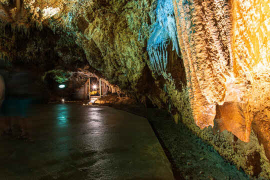 Illuminated Lipa Cave interior in Montenegro with walkway and karst formations