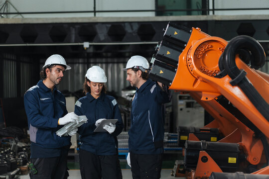 Professional robotic technician team discussing plan working for robot assembly component from customer specifications in robot warehouse. system integration, precision adjustment.