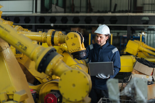 Professional technician inspecting industrial robotic arm in warehouse with laptop, robot programming, automation software, precision, calibration, safety, quality control before customer delivery.