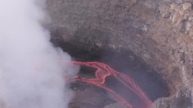 Erta Ale volcano, View of the glowing lava lake inside the crater, with molten rock patterns and dark volcanic rock walls in Zone 2, Afar, Ethiopia.