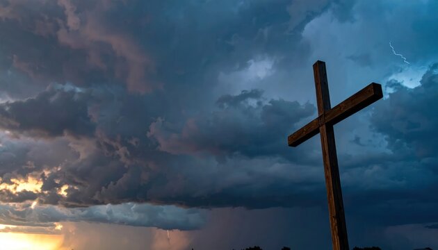 Wooden Cross Silhouetted Against Dramatic Stormy Sky with Setting Sun.