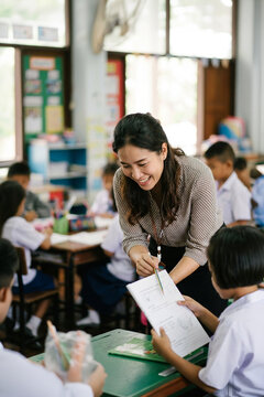 Teacher helping student with schoolwork in classroom