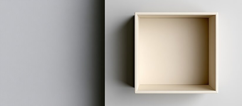 Top-down view of an empty, light-colored, rectangular wooden box on a gray surface