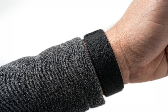 Close up of a black wristband on a person's arm