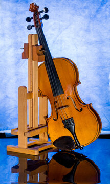 Still life with a violin and stand on a blue background