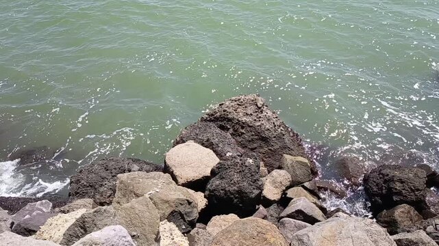 Serene coastal scene showcasing a stretch of beach with a rocky shoreline and gentle waves capturing the tranquil beauty of nature's shoreline environment perfect for relaxation and outdoor leisure ac