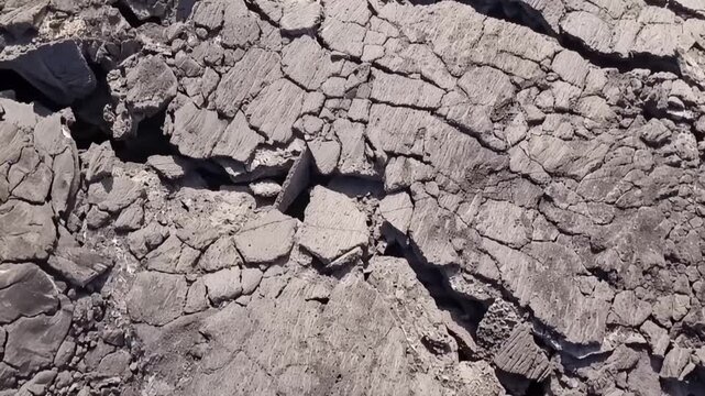 Erta Ale volcano, Aerial view of cracked and solidified lava crust of the Erta Ale volcano, showing deep fissures and jagged volcanic rock formations in Zone 2, Afar, Ethiopia.