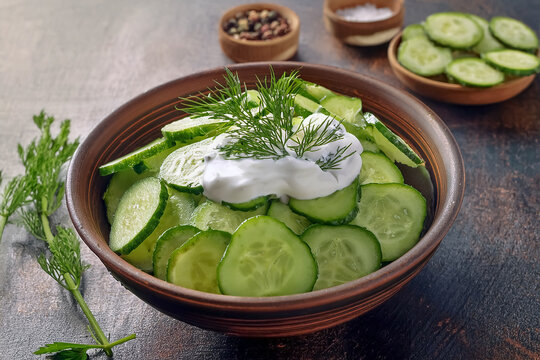 Eine Sch&uuml;ssel mit Gurken in Schheiben geschnitten und dar&uuml;ber lecker Dressing f&uuml;r einen Salat
