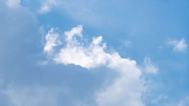 Close-up of soft white clouds against a blue sky with natural daylight. High resolution atmospheric background for design and advertising.