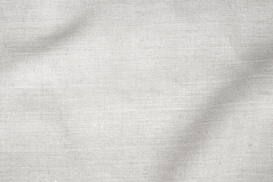 White linen fabric texture with soft shadow and natural copy space. Elegant textile background for branding, skincare, packaging, product display and minimal design.