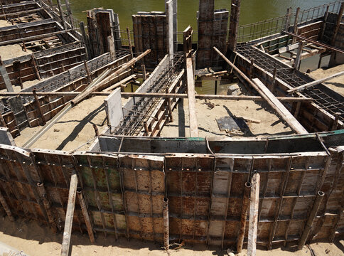 Building process city levee. Exposed foundation rebar grid at site, standing formwork and concrete footings